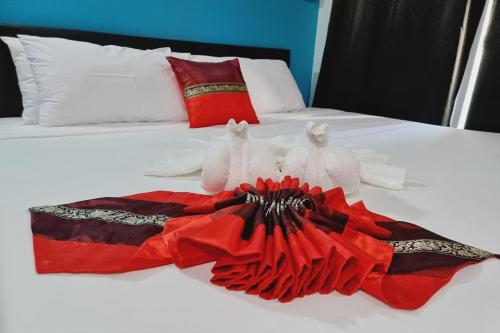 two towels on a bed with a red dress at Chat House Chiang Rai in Chiang Rai