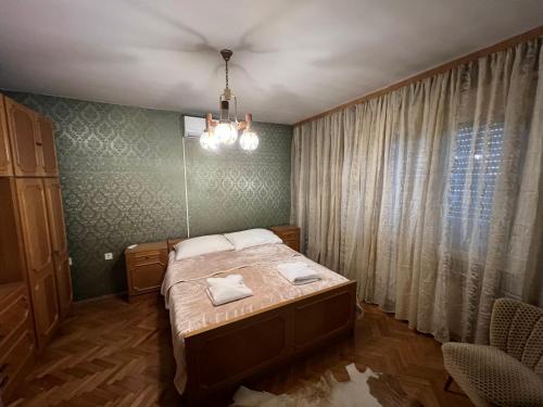 a bedroom with a bed and a chandelier at IDa House in Sveti Ivan Zelina