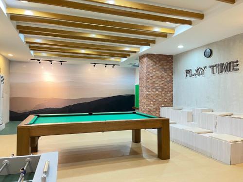 a pool table in a room with a playtime sign on the wall at The Nook Cabin in Tagaytay
