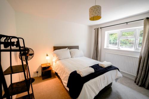 a bedroom with a bed and a window at Cliveden Garden Cottage sleeps 6 - With Hot Tub, Parking, in Taplow - next to Cliveden National Park in Maidenhead