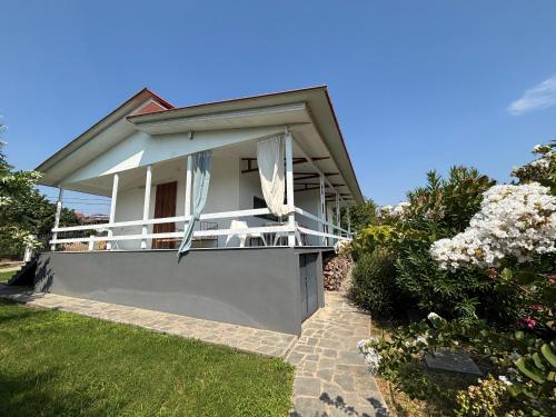 a white house with a balcony in a yard at Modern Summer House Popi in Pálioura