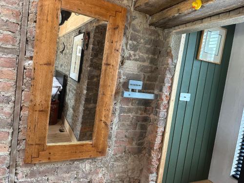 a mirror on a brick wall next to a green door at Castle Street in Balnacart