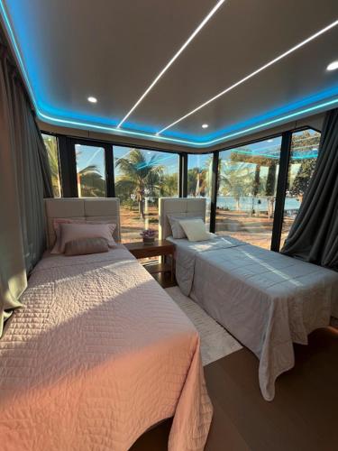 two beds in a room with windows at Pousada Ilha Canela in Palmas