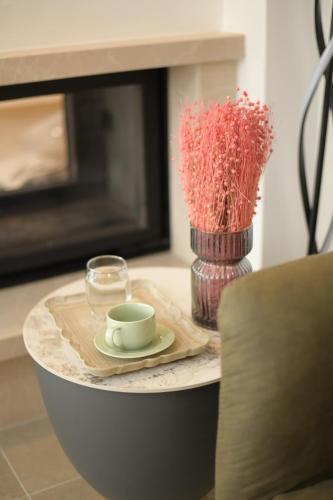 a table with a cup of coffee and a vase with a glass at Monte zone in Žabljak