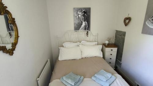 a small bedroom with a bed with towels on it at The Farmhouse La Drutière in Saint-Sauveur-de-Carrouges