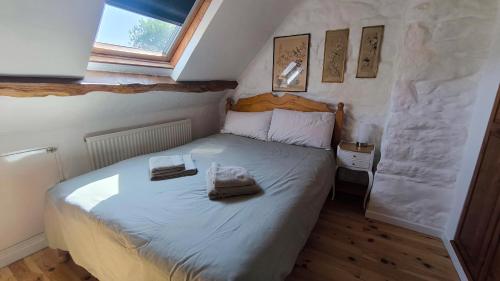 a bedroom with a bed with two towels on it at The Farmhouse La Drutière in Saint-Sauveur-de-Carrouges