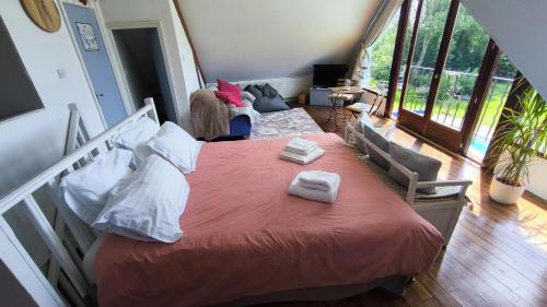 a bedroom with a bed with two towels on it at The Farmhouse La Drutière in Saint-Sauveur-de-Carrouges