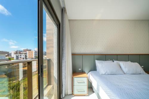 Sunrise Residence في بومبينهاس: غرفة نوم مع سرير وشرفة