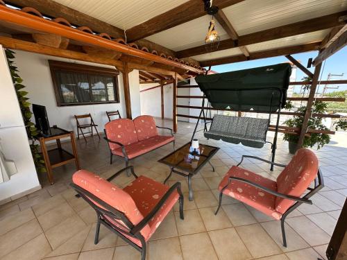 a screened in porch with chairs and a table at Bratis House 2 in Vartholomio