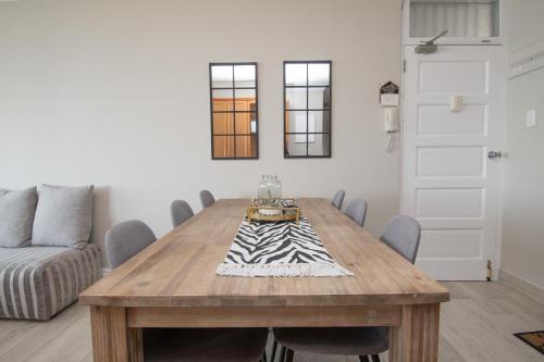 a dining room with a wooden table and chairs at 64 Sea Lodge Umhlanga Rocks in Durban