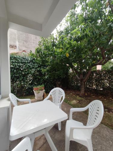 a white table and two white chairs on a patio at Ravkin Apartments in Zadar