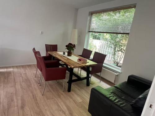 Una sala de estar con una mesa y sillas de madera. en Peaceful Home Near Nature, en Glimmen