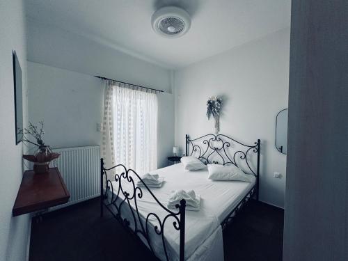 una camera da letto con un letto bianco e un tavolo di Portolos Apartments - Filiatro a Vathi