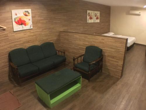 a hospital room with a couch and a bed at Talents Motor Park Hotel in Klang