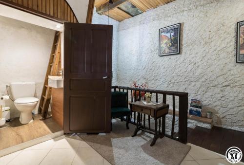 a bathroom with a toilet and a wooden door at Escapade lauragaise in Saint-Félix-Lauragais