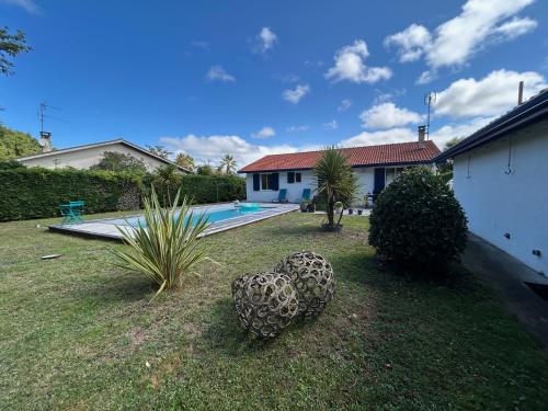 une cour avec deux grandes sphères dans l'herbe dans l'établissement Maison familiale avec piscine, à La Teste-de-Buch