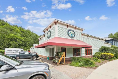 a car parked in front of a building with a clock at Riverside Getaway in Stowe