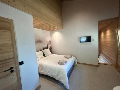 a bedroom with a bed and a tv on the wall at 35 m2 duplex in a new 2025 chalet in Saint-Gervais-les-Bains