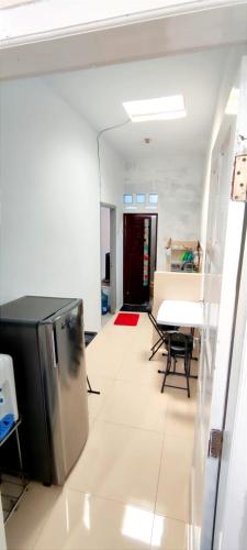 a living room with a table and a refrigerator at Naya Homestay Kuningan in Balong