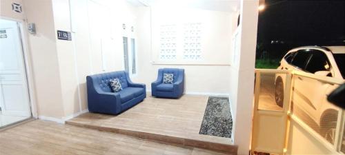 two blue chairs in a room with a car at Naya Homestay Kuningan in Balong