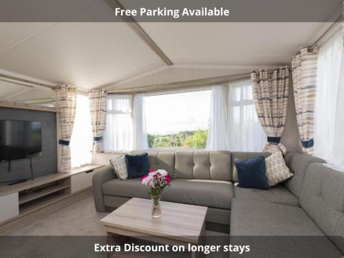 a living room with a couch and a tv at Tencreek Holiday Park in Looe