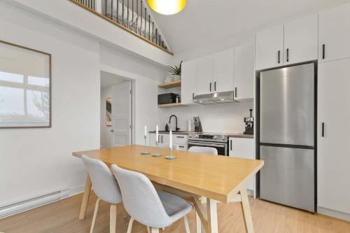 a kitchen and dining room with a wooden table and chairs at Elska - SPA and Mountain in Saint Come