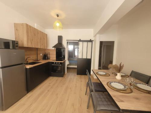 a kitchen with a wooden table and a refrigerator at l'Horizon in Fos-sur-Mer