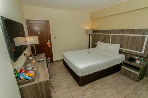 a hotel room with a bed and a table at Rado Hotel - Quintanas in Trujillo