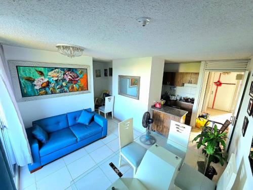 a living room with a blue couch and a kitchen at Apartment near U San Buenaventura in Cartagena de Indias