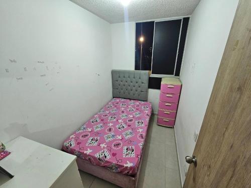 a small bedroom with a pink bed and a pink dresser at Apartment near U San Buenaventura in Cartagena de Indias
