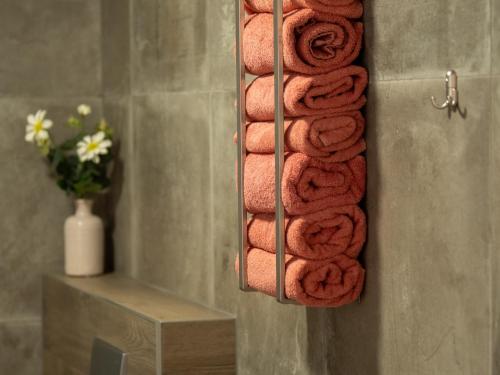 a bunch of towels hanging on a towel rack in a bathroom at Vakantiehuisjes "De Veldzijde" in Losser