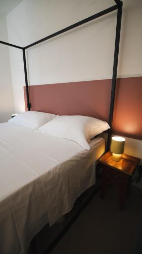 a bedroom with a bed and a table with a lamp at Casa Cucunci in Modica