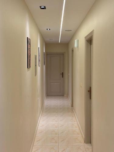 an empty hallway with a white door and a hallwayngth at Pyramids Green View in Cairo