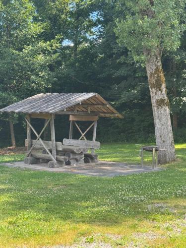 a wooden shelter in a park with a tree at Altmarkblick in Erbenhausen