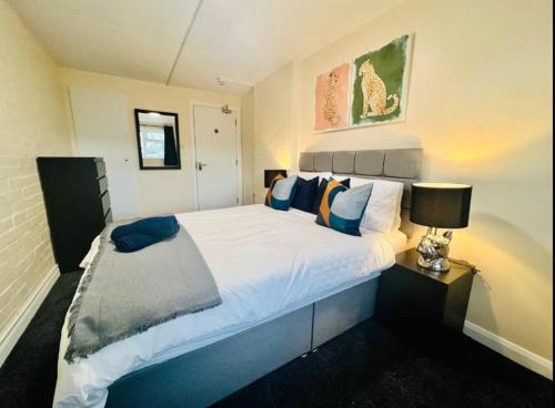 a bedroom with a large white bed and a lamp at Spacious 6 Bedroom House with Free Parking for Contractors and Business in Basildon