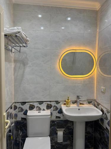 a bathroom with a white toilet and a sink at Pyramids Green View in Cairo