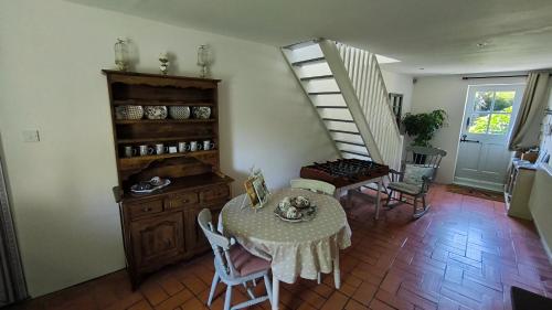 a dining room with a table and a staircase at The Farmhouse La Drutière in Saint-Sauveur-de-Carrouges