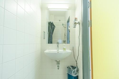 a white bathroom with a sink and a mirror at Hotel Astral Vienna in Vienna