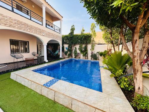 バマコにあるVilla So queen avec piscineの家の裏庭にあるプール