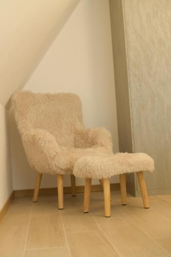 a furry chair with wooden legs in a room at Monte zone in Žabljak