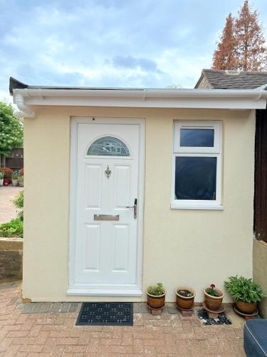 ルートンにあるThe Garden Studio - Private, Modern, Cozy, Ensuite in a Quiet Areaの白い扉のある家