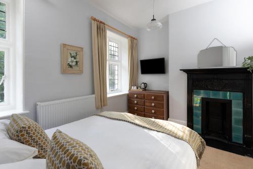 a bedroom with a bed and a fireplace at The Hunters Inn in Martinhoe