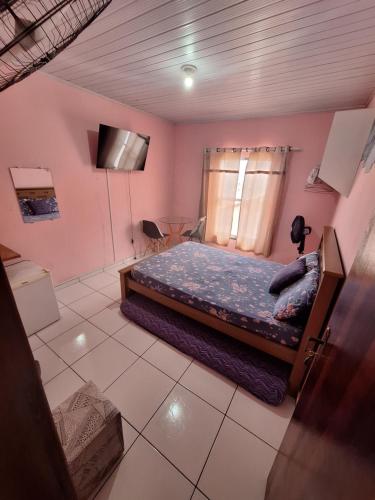 a bedroom with a bed and a television in it at Quartos da lagoa in Cabo Frio
