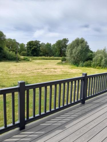 a wooden bridge with a field in the background at Pullman Lodge in Glemsford