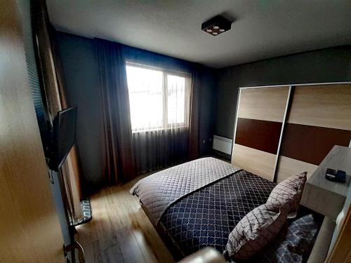 ein Schlafzimmer mit einem Bett und einem Fenster in der Unterkunft Апартамент за гости в Пампорово in Pamporowo