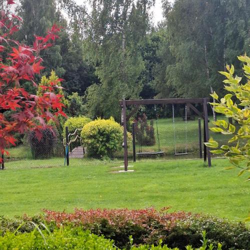 a park with a swing in the grass at Apartamenty TUTERRA III in Zabagnie