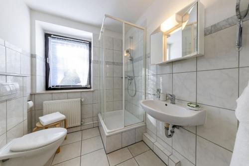 a white bathroom with a sink and a toilet at AMAYA SUITES nahe Heide Park, Serengeti Park & A7 in Soltau