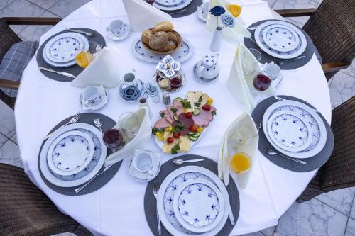 a white table with plates of food on it at AMAYA SUITES nahe Heide Park, Serengeti Park & A7 in Soltau