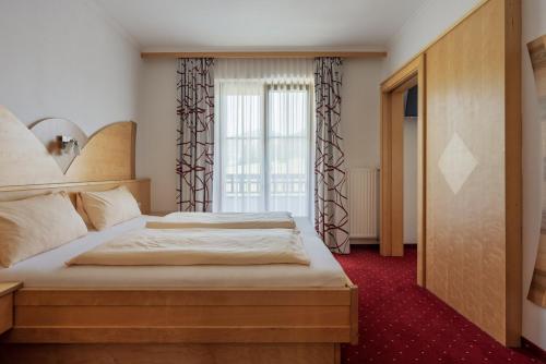 a bedroom with two beds and a large window at Embacherhof in Embach