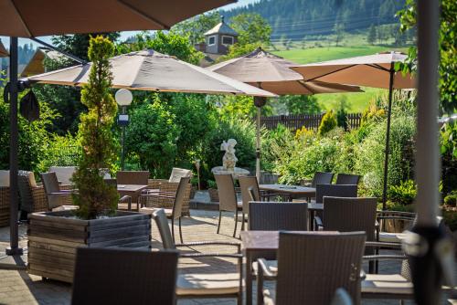 an outdoor patio with tables and chairs and umbrellas at Embacherhof in Embach